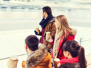 Image showing happy friends with coffee cups on skating rink