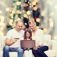 Image showing happy family with laptop computer and credit card