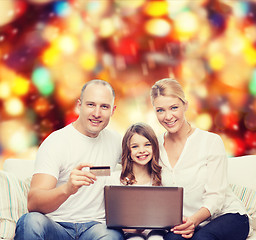 Image showing happy family with laptop computer and credit card