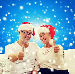 Image showing happy senior couple in santa helper hats