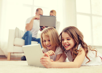 Image showing smiling sister with tablet pc and parents on back