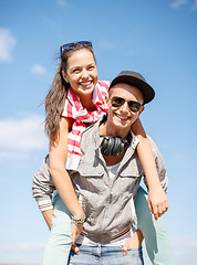 Image showing smiling teenagers in sunglasses having fun outside
