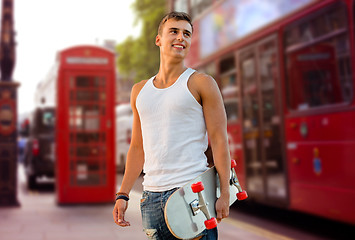 Image showing smiling man with skateboard on london city street