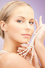 Image showing beautiful woman with pearl necklace over violet