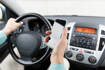 Image showing close up of man hand with smartphone driving car