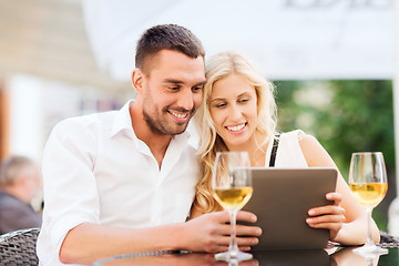 Image showing happy couple with tablet pc at restaurant lounge