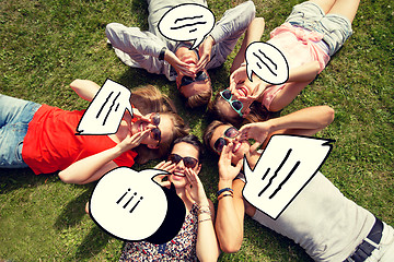 Image showing group of smiling friends lying on grass outdoors