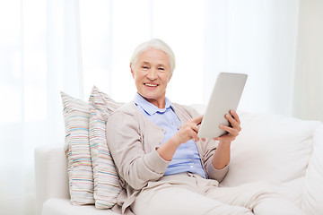 Image showing happy senior woman with tablet pc at home