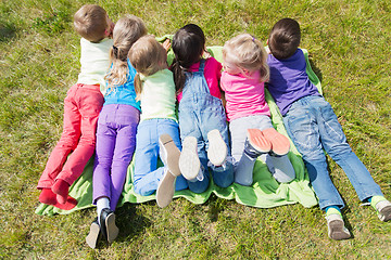 Image showing group of kids lying on blanket or cover outdoors