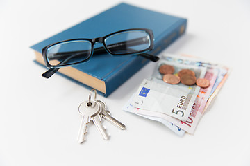 Image showing close up of book, money, glasses and keys on table