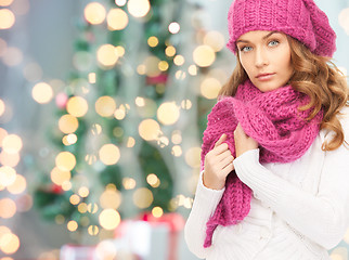 Image showing woman in hat and scarf over christmas tree lights