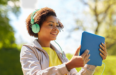 Image showing happy african woman with tablet pc and headphones