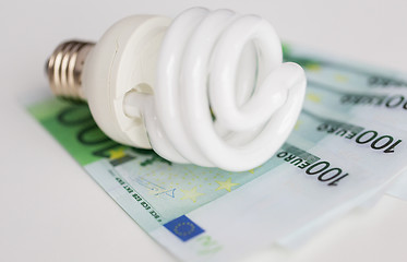 Image showing close up of euro money and light bulb on table