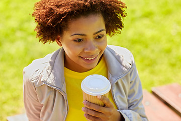 Image showing smiling african woman drinking coffee outdoors 