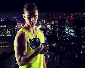 Image showing young man with dumbbell flexing biceps