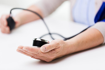 Image showing old woman with tonometer checking blood pressure