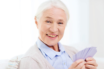 Image showing happy senior woman playing cards at home