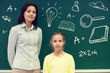 Image showing little school girl with teacher at blackboard