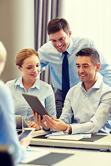 Image showing smiling business people with tablet pc in office