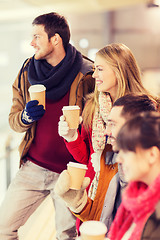 Image showing happy friends with coffee cups on skating rink