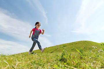 Image showing happy little girl running on green summer field