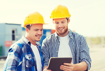 Image showing smiling builders in hardhats with tablet pc