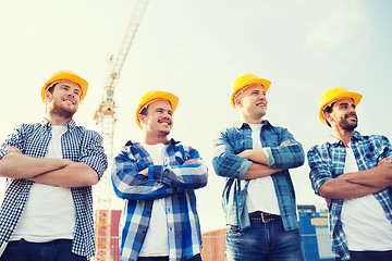 Image showing group of smiling builders in hardhats outdoors