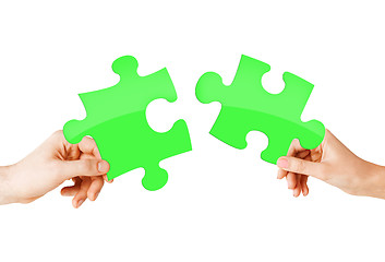 Image showing close up of couple hands with green puzzle pieces