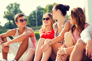 Image showing group of smiling friends sitting on city street