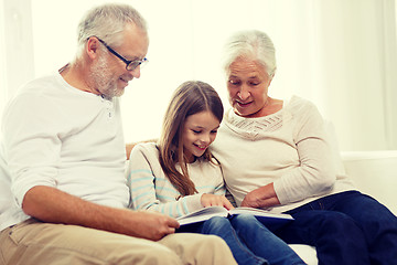 Image showing smiling family with book at home