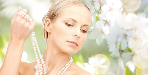 Image showing woman with pearl necklace over cherry blossom