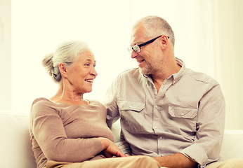 Image showing happy senior couple hugging on sofa at home