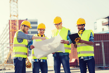 Image showing group of builders with tablet pc and blueprint