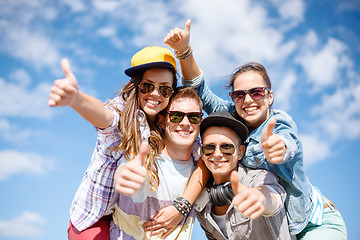 Image showing smiling teenagers in sunglasses hanging outside