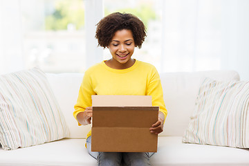 Image showing happy african young woman with parcel box at home