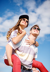 Image showing smiling teenagers in sunglasses having fun outside