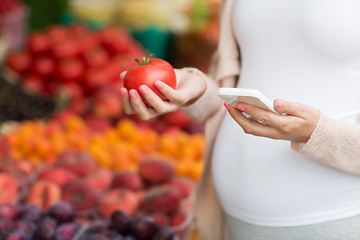 Image showing pregnant woman with smartphone at street market