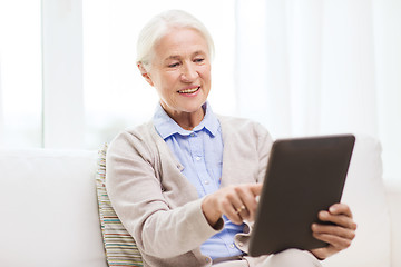 Image showing happy senior woman with tablet pc at home