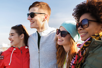 Image showing happy teenage friends in shades hugging outdoors