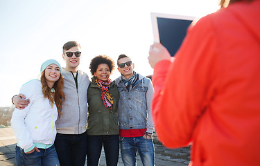 Image showing happy teenage friends with tablet pc photographing