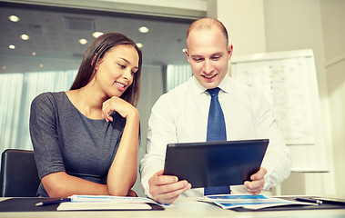 Image showing smiling businesspeople with tablet pc in office