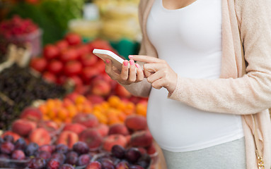 Image showing pregnant woman with smartphone at street market