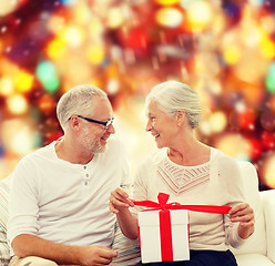 Image showing happy senior couple with gift box at home