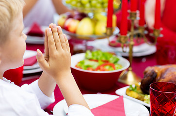 Image showing close up of boy praying at christmas dinner