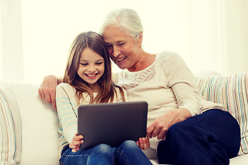 Image showing smiling family with tablet pc at home