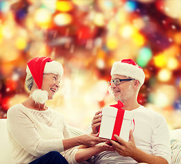 Image showing happy senior couple with gift box at home