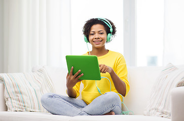 Image showing happy african woman with tablet pc and headphones