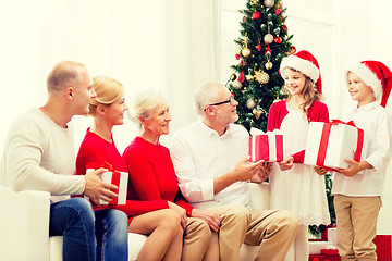 Image showing smiling family with gifts at home