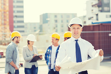 Image showing group of builders with tablet pc and blueprint