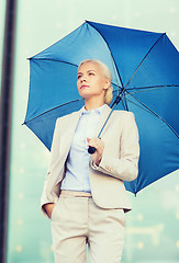 Image showing young serious businesswoman with umbrella outdoors